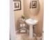 Small powder room with pedestal sink and mirrored vanity at 27002 W Oraibi Dr, Buckeye, AZ 85396