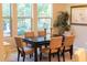 Formal dining room with a dark wood table, six beige chairs, and large windows at 27002 W Oraibi Dr, Buckeye, AZ 85396