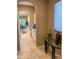 Elegant hallway with glass-top accent table and view into kitchen at 27002 W Oraibi Dr, Buckeye, AZ 85396