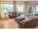 Spacious living room with two brown sofas, a coffee table, and large windows with backyard view at 27002 W Oraibi Dr, Buckeye, AZ 85396