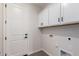 Laundry room with white cabinets and built-in shelving at 17389 W El Caminito Dr, Waddell, AZ 85355