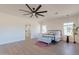 Bright bedroom with wood-look floors, a ceiling fan, and en-suite bathroom access at 3939 S Veronica Ln, Gold Canyon, AZ 85118