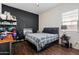 Spacious bedroom with a large bed, dark-colored wall, and wood-look flooring at 10737 E Simone Ave, Mesa, AZ 85212