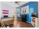 Charming bedroom with blue accent wall, a bed, dresser, and TV at 10737 E Simone Ave, Mesa, AZ 85212