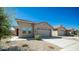 Tan house with a two car garage and landscaping at 16543 W Alameda Rd, Surprise, AZ 85387