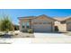 Tan house with a two car garage and landscaping at 16543 W Alameda Rd, Surprise, AZ 85387