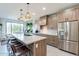 Modern kitchen with wood cabinets, stainless steel appliances, and an island with seating at 142 E Hearne Way, Gilbert, AZ 85234