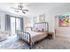 Spacious bedroom with a metal bed frame, ceiling fan, and access to a balcony at 142 E Hearne Way, Gilbert, AZ 85234
