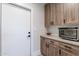 Laundry room with wood cabinets, countertop, and built-in oven at 142 E Hearne Way, Gilbert, AZ 85234
