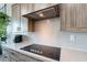 Modern gas cooktop and light gray quartz countertop with wood cabinets at 142 E Hearne Way, Gilbert, AZ 85234