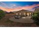 Backyard patio with fire pit and seating at sunset at 1448 E Poncho Ln, San Tan Valley, AZ 85143