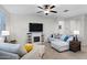 Comfortable living room with L-shaped sofa, fireplace, and large TV at 41692 W Monsoon Ln, Maricopa, AZ 85138