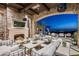 Covered patio with fireplace, comfortable seating, and mountain views at 11200 E Canyon Cross Way, Scottsdale, AZ 85255