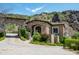Stone house exterior with lush landscaping and mountain views at 11200 E Canyon Cross Way, Scottsdale, AZ 85255