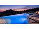 Infinity pool with a spa and mountain views at sunset at 11200 E Canyon Cross Way, Scottsdale, AZ 85255