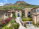 Stone mansion with grand staircase, mountain views, and lush landscaping at 11200 E Canyon Cross Way, Scottsdale, AZ 85255