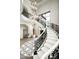 Elegant curved staircase with wrought iron railing and crystal chandelier at 11200 E Canyon Cross Way, Scottsdale, AZ 85255