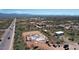 Aerial view of a house under construction near a highway, showing its progress in a desert environment at 28021 N 156Th St, Scottsdale, AZ 85262