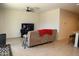 Living room features a large TV, ceiling fan and comfortable seating at 31021 W Columbus Ave, Buckeye, AZ 85396