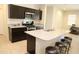 Island kitchen with dark cabinetry, granite countertops, and stainless steel appliances at 31021 W Columbus Ave, Buckeye, AZ 85396