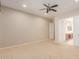 Bright bedroom with ceiling fan and doors leading to the bathroom at 26990 W Burnett Rd, Buckeye, AZ 85396