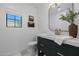 Modern bathroom with dark vanity, marble countertop, and brass fixtures at 10755 E Cholla Ln, Scottsdale, AZ 85259