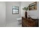 Small powder room with a floating toilet and wooden dresser at 10755 E Cholla Ln, Scottsdale, AZ 85259