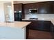 Modern kitchen with dark cabinets and quartz countertops at 21042 E Camina Buena Vis, Queen Creek, AZ 85142