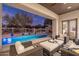 Relaxing backyard oasis featuring a sparkling pool, patio furniture, and string lights at 7056 E Mighty Saguaro Way, Scottsdale, AZ 85266