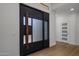 Modern front door with a wood accent and frosted glass panels at 7056 E Mighty Saguaro Way, Scottsdale, AZ 85266