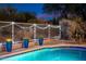 Relaxing pool area with a metal fence, string lights, and potted plants at 7056 E Mighty Saguaro Way, Scottsdale, AZ 85266
