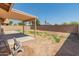 Backyard with grassy area, covered patio, and hose reel at 17613 N Kimberly Way, Surprise, AZ 85374