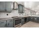 Modern kitchen with gray cabinets, stainless steel range, and tile backsplash at 7221 W Globe Ave, Phoenix, AZ 85043