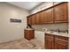 Laundry room with wood cabinets, granite countertop, and a utility sink at 127 E Sabrosa Dr, New River, AZ 85087