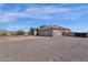 Tan two-car garage, paved driveway, and gravel yard at 127 E Sabrosa Dr, New River, AZ 85087