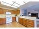 Kitchen with wood cabinets, white appliances, and laminate floor at 8217 E Natal Ave, Mesa, AZ 85209