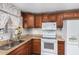 Kitchen corner with wood cabinets, granite counters, and a double sink at 6565 N 19Th Ave # 21, Phoenix, AZ 85015
