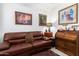 Home office with a leather couch, antique roll top desk, and framed artwork at 1451 E Palm Beach Dr, Chandler, AZ 85249