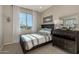 Charming bedroom with dark wood dresser and striped bedding at 18162 W Cielo Grande Ave, Surprise, AZ 85387