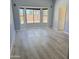 Bright living room featuring large windows and wood-look flooring at 20411 N 99Th Dr, Peoria, AZ 85382