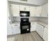 Modern kitchen with white cabinets, black appliances, and quartz countertops at 20411 N 99Th Dr, Peoria, AZ 85382