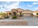 House exterior, tan colored with stone accents and a two car garage at 34218 N 26Th Ave, Phoenix, AZ 85085