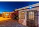 Small casita with an ornate metal door, surrounded by desert landscaping at night at 9645 E Brown Rd, Mesa, AZ 85207