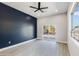 Bedroom with a large window, sliding glass door to backyard, and navy blue accent wall at 2122 W Virginia Ave, Phoenix, AZ 85009