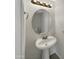 Small bathroom with pedestal sink and round mirror at 1081 W 1St St # 7, Tempe, AZ 85281