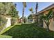 Spacious backyard with grassy lawn, mature trees, and a private gate at 4525 N 66Th St # 48, Scottsdale, AZ 85251