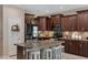 Stylish kitchen with dark wood cabinets, granite countertops and island at 7715 S 69Th Ln, Laveen, AZ 85339
