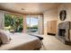 Main bedroom with fireplace, large windows, and views of the pool at 10626 E Palo Brea Dr, Scottsdale, AZ 85262