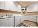 Bright laundry room with modern appliances and cabinets at 10626 E Palo Brea Dr, Scottsdale, AZ 85262