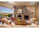 Spacious living room with stone fireplace, large windows, and comfortable seating at 10626 E Palo Brea Dr, Scottsdale, AZ 85262